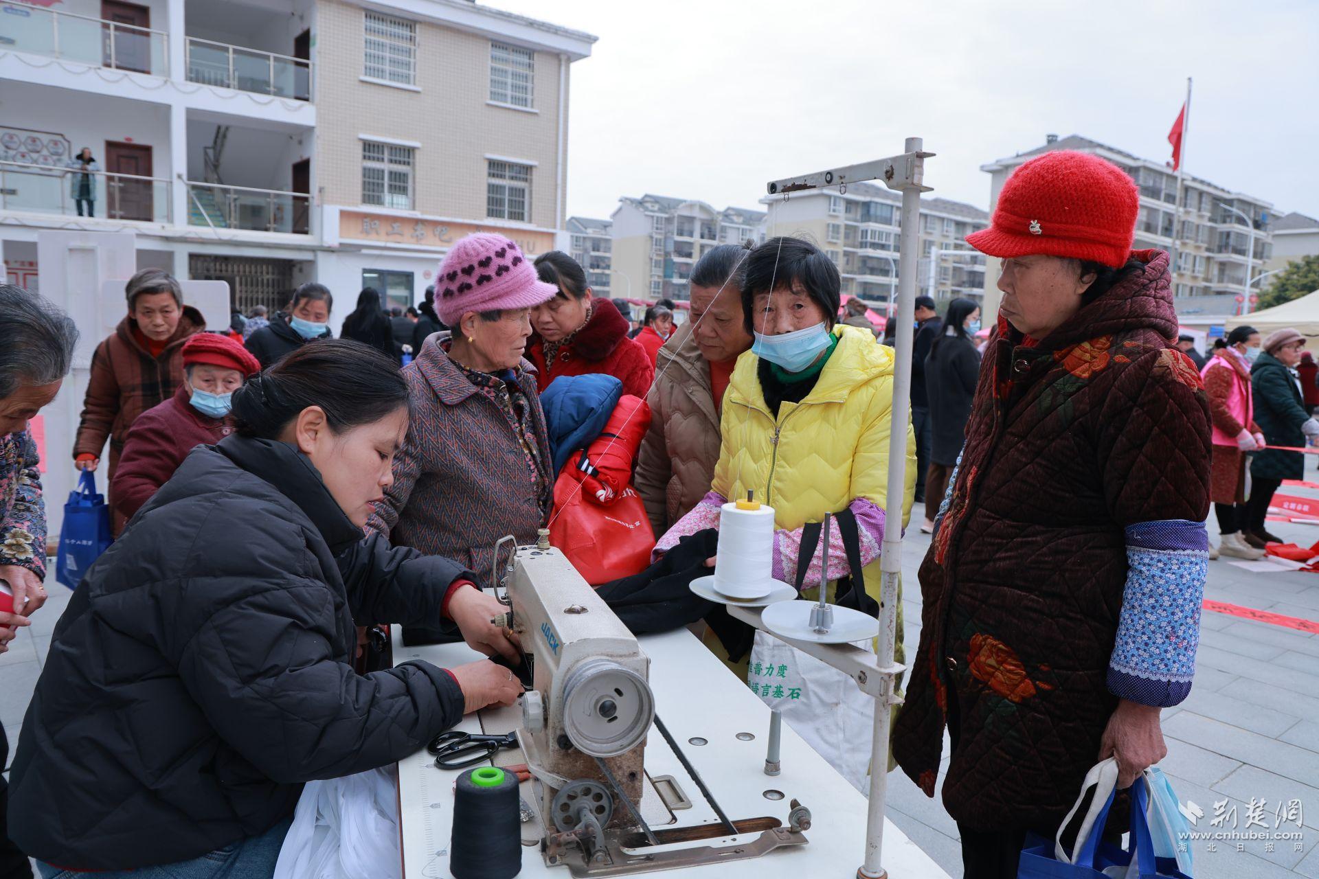 衣物縫補(bǔ)攤前，志愿者飛針走線為居民修補(bǔ)破損衣物.jpg.jpg